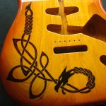 Close-up view of Celtic dragon design woodburned on guitar body