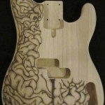 Full view of human brain design woodburned on bass guitar body - raw wood.